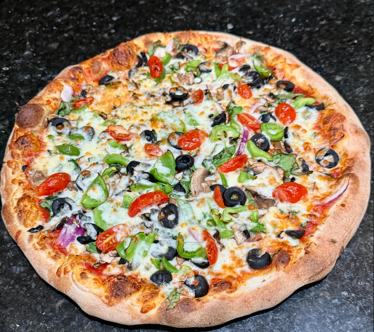 Loaded veggie pizza with olives, peppers, and tomatoes